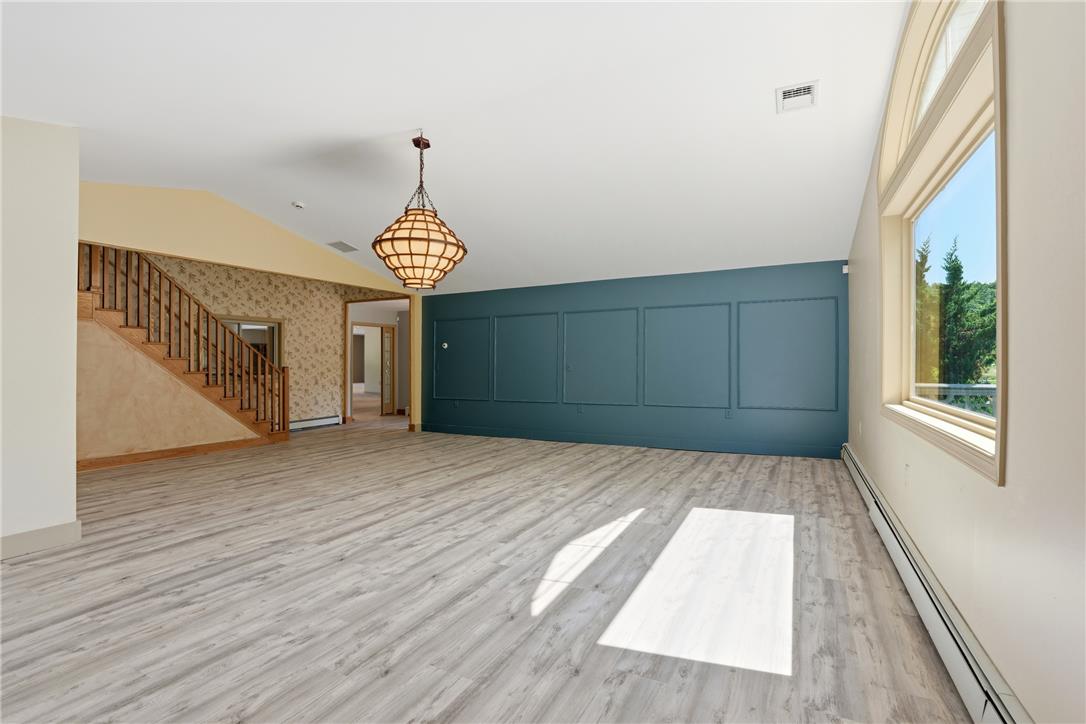 6271 Batman Road Zionsville, PA 18092 - Photo 24 of 100 An airy living space features wood-style flooring, ample natural light, and a grand staircase.