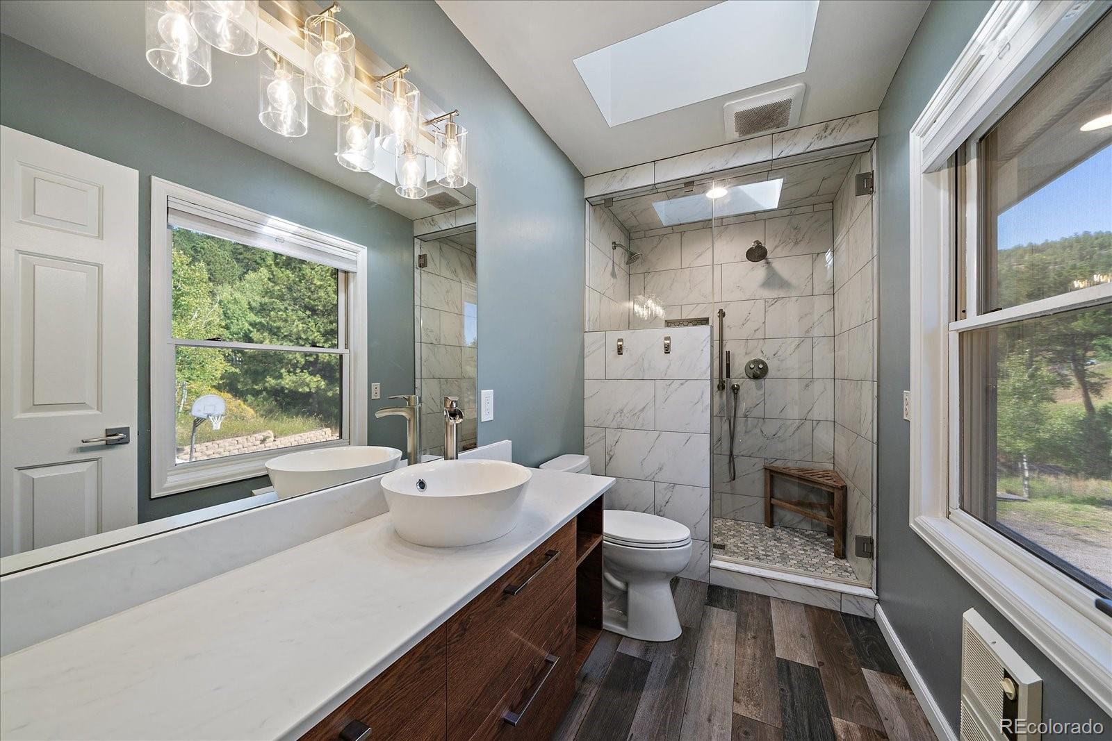 11842 South Geronimo Trail Conifer, CO 80433 - Photo 19 of 41 a bathroom with a sink a toilet a large mirror and a tub