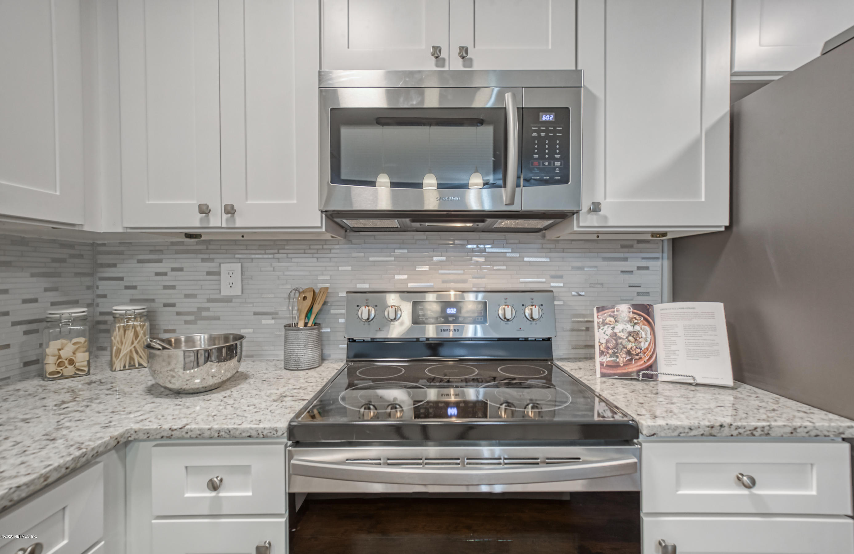6711 Ryance Road Jacksonville, FL 32211 - Photo 12 of 26 a kitchen with granite countertop a stove top oven a sink and dishwasher