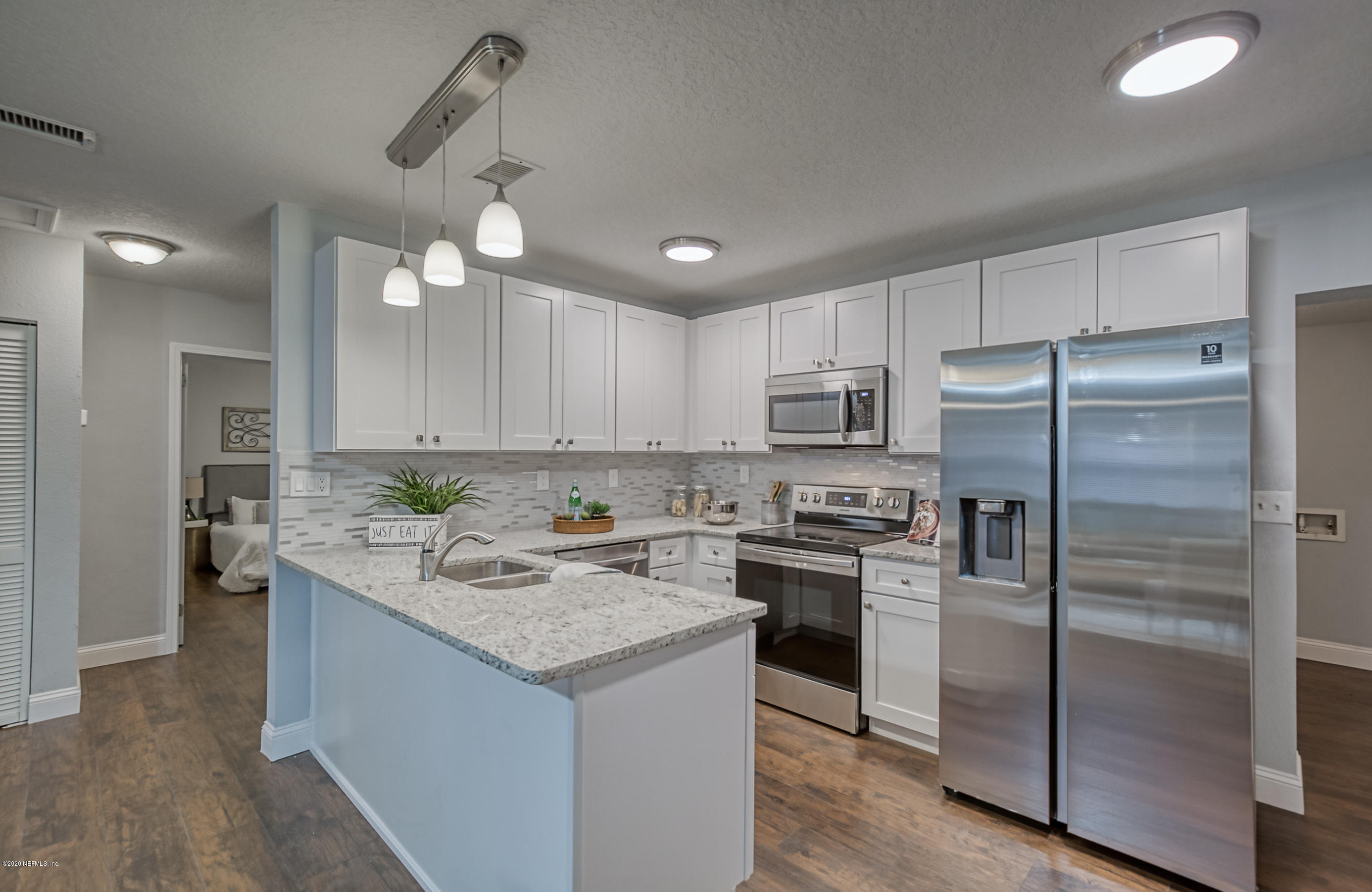 6711 Ryance Road Jacksonville, FL 32211 - Photo 9 of 26 a kitchen with a refrigerator a sink a stove a microwave and island