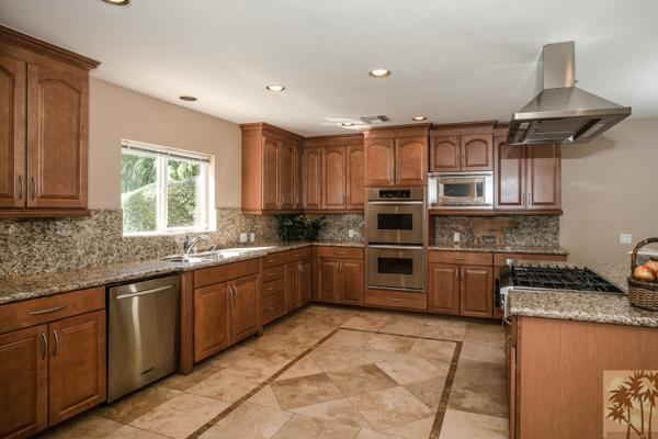 a kitchen with stainless steel appliances granite countertop a stove sink and cabinets