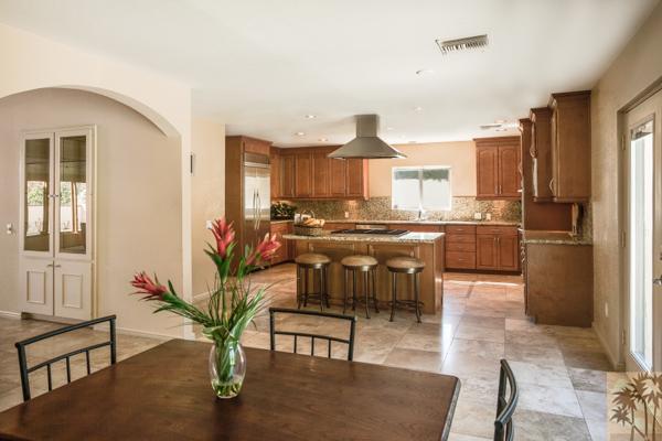 2 Boothill Circle Rancho Mirage, CA 92270 - Photo 25 of 42 a kitchen with stainless steel appliances kitchen island granite countertop a table chairs in it and wooden floors