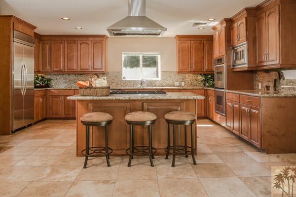 2 Boothill Circle Rancho Mirage, CA 92270 - Photo 26 of 42 a kitchen with granite countertop a table chairs stove top oven and cabinets