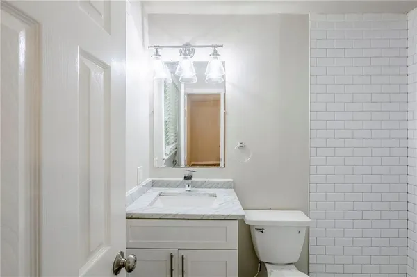 a bathroom with a toilet sink and mirror