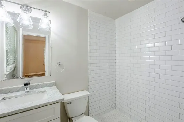 a bathroom with a toilet a sink and mirror
