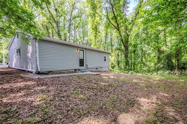 a backyard of a house with large trees and garage