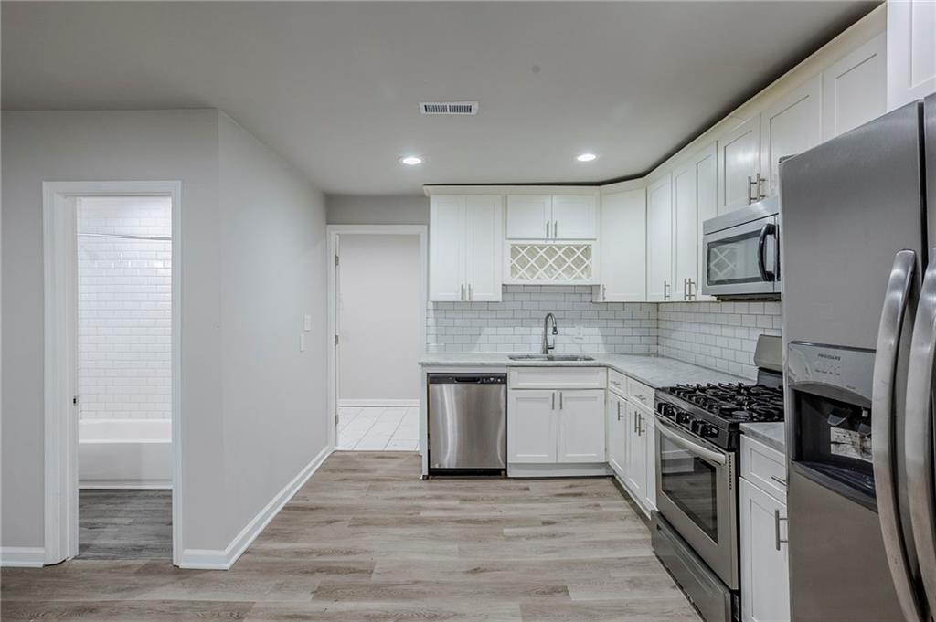 3735 Boulder Park Drive Southwest Atlanta, GA 30331 - Photo 3 of 29 a kitchen with stainless steel appliances granite countertop a stove top oven a sink and a refrigerator