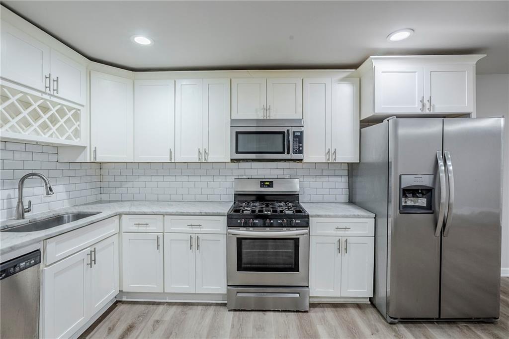 3735 Boulder Park Drive Southwest Atlanta, GA 30331 - Photo 4 of 29 a kitchen with white cabinets sink and stainless steel appliances