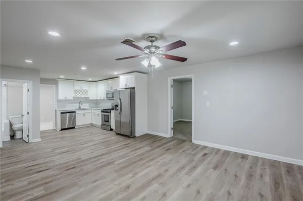 a view of an empty room with a kitchen