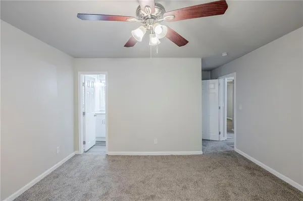 an empty room with closet and a chandelier fan