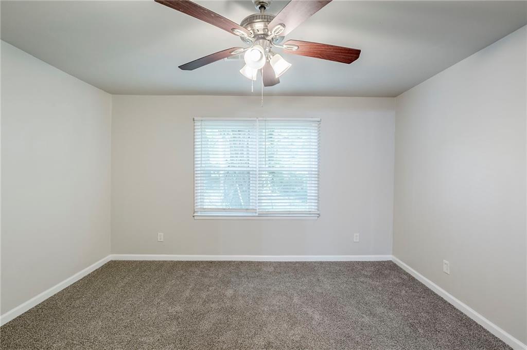 3735 Boulder Park Drive Southwest Atlanta, GA 30331 - Photo 10 of 29 an empty room with a chandelier fan and windows