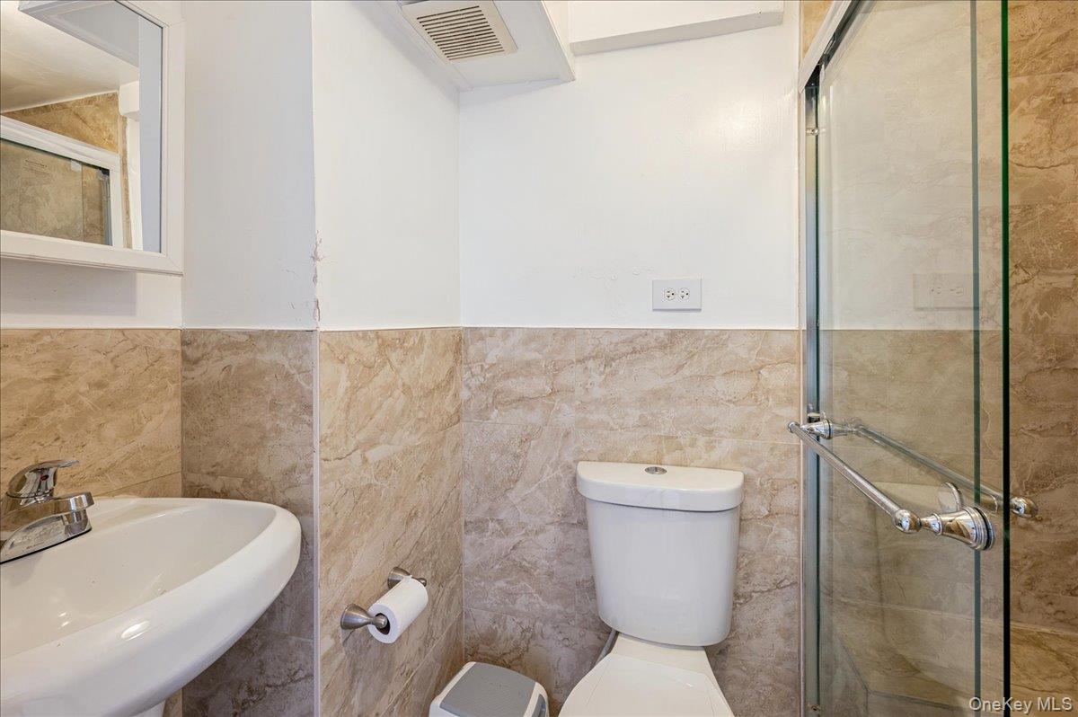 412 Calhoun Avenue Bronx, NY 10465 - Photo 19 of 26 a bathroom with a sink a toilet and a mirror