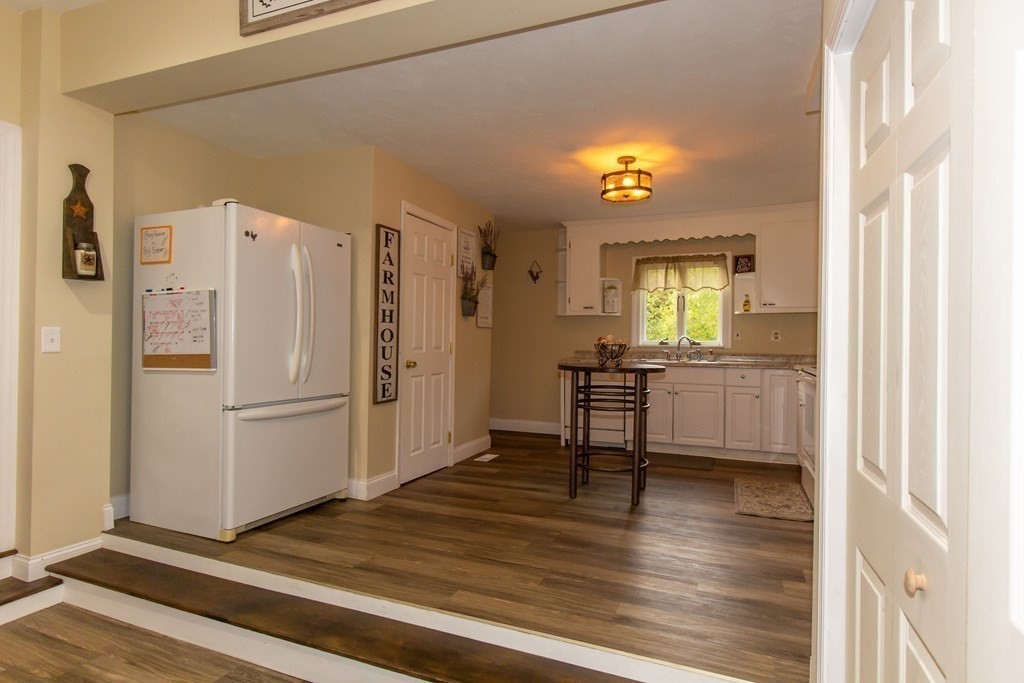 28 Flagg Road Hubbardston, MA 01452 - Photo 14 of 40 a view of a kitchen with a refrigerator a cabinet and a fireplace