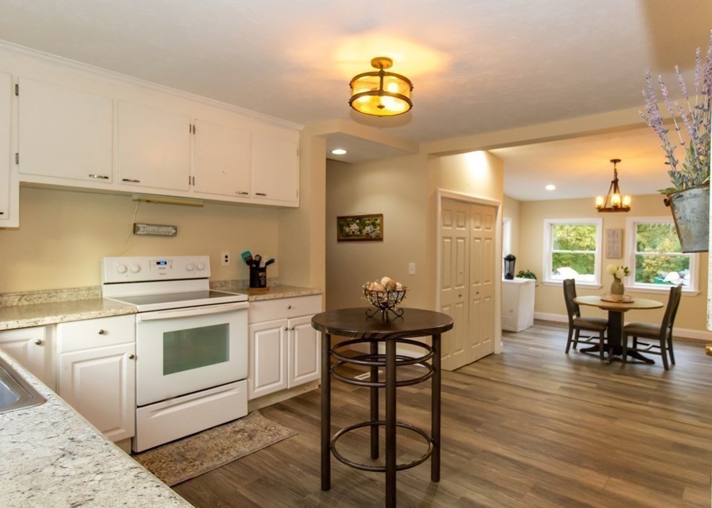 28 Flagg Road Hubbardston, MA 01452 - Photo 17 of 40 a kitchen with a dining table chairs and white cabinets