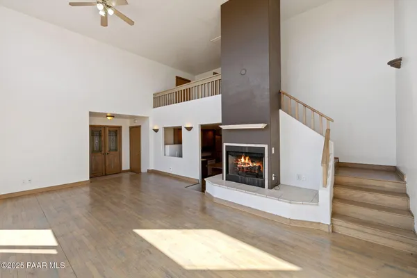 a view of a livingroom with wooden floor and a fireplace