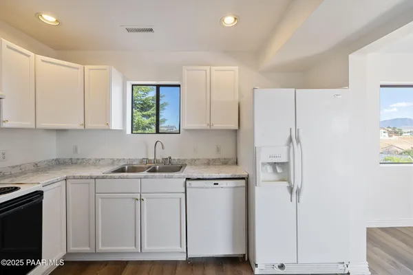 a view of a kitchen with a sink a ceiling fan and refrigerator