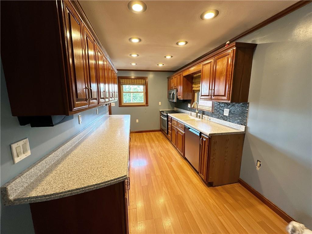 401 Clements Road Pittsburgh, PA 15239 - Photo 11 of 24 a large kitchen with stainless steel appliances granite countertop a large counter top a stove and a wooden floors