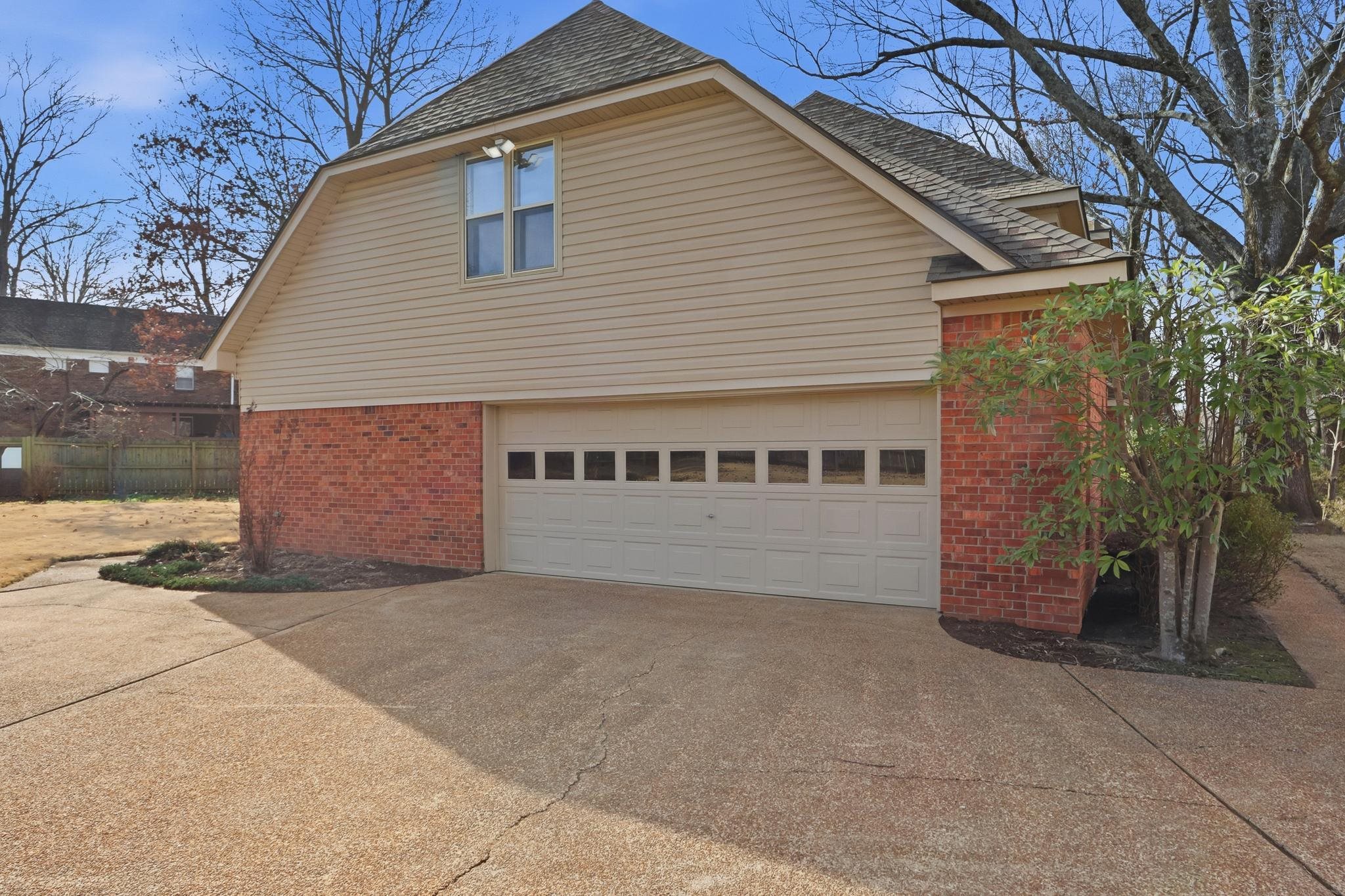 2670 Stout Rd Cove Memphis, TN 38119 - Photo 34 of 37 View of side of home with brick siding, concrete driveway, a shingled roof, and a garage