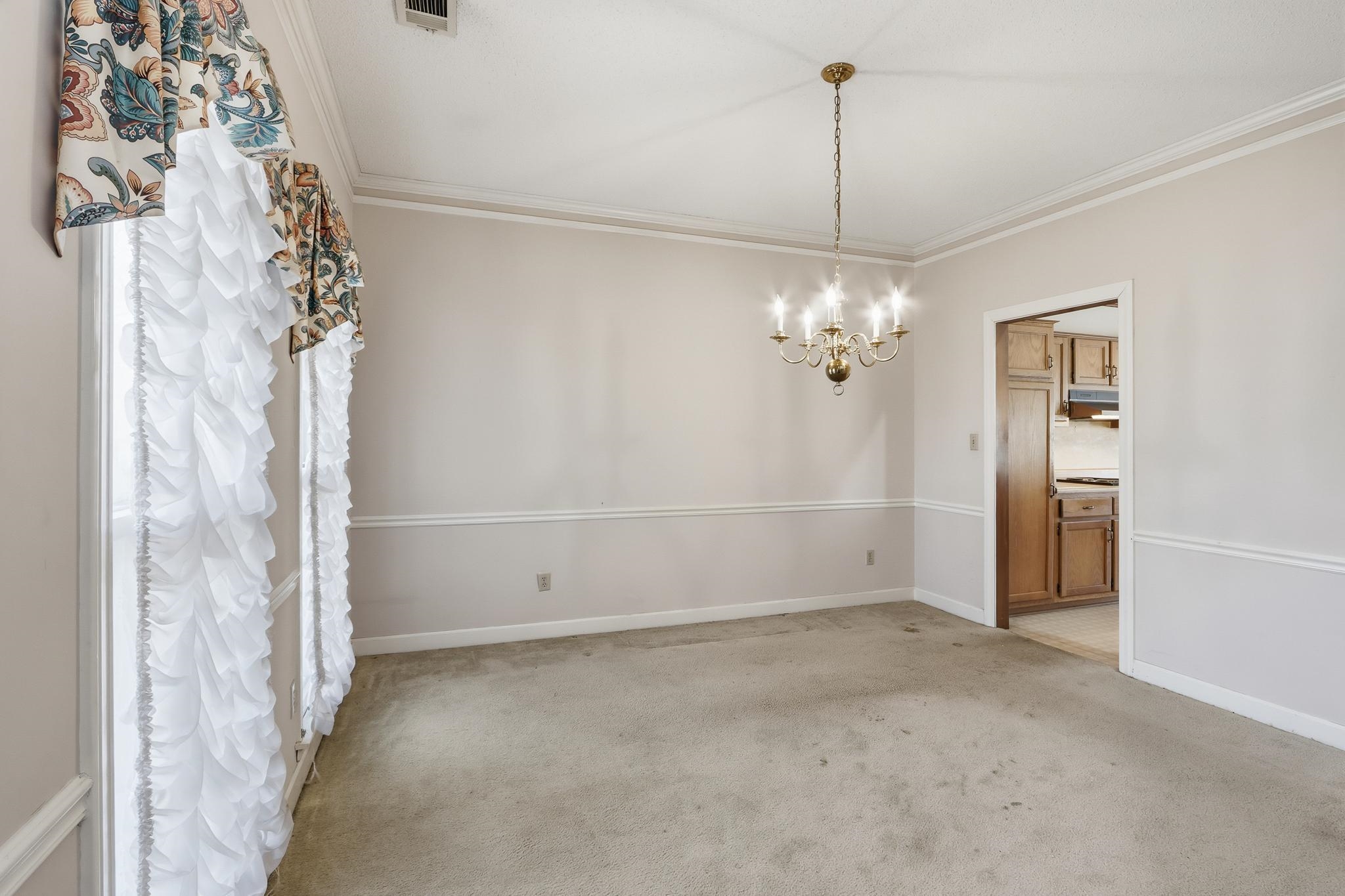2670 Stout Rd Cove Memphis, TN 38119 - Photo 9 of 37 Unfurnished dining area featuring a chandelier, light colored carpet, and crown molding