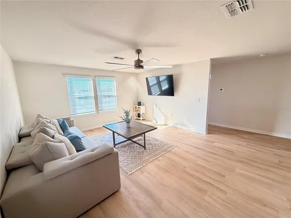 a living room with furniture and a wooden floor