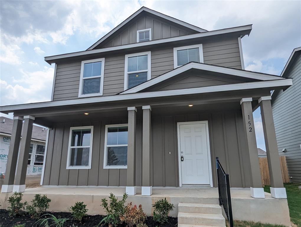 A welcoming front porch leads to this charming residence with tidy landscaping.