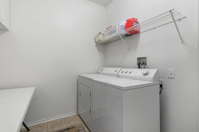 a view of a house with a small yard and floor to ceiling window and a large tree