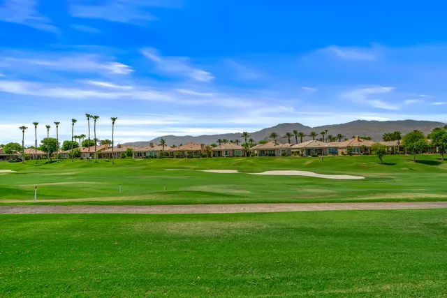 a living room with furniture a large window and chandelier