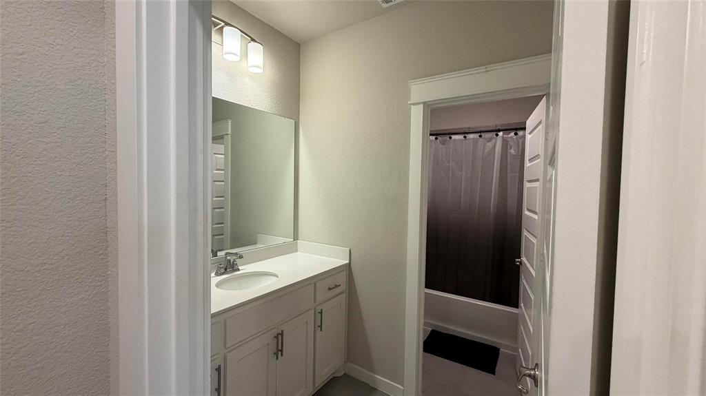912 Fallbrook Avenue Denton, TX 76210 - Photo 19 of 26 a bathroom with a double vanity sink and a mirror