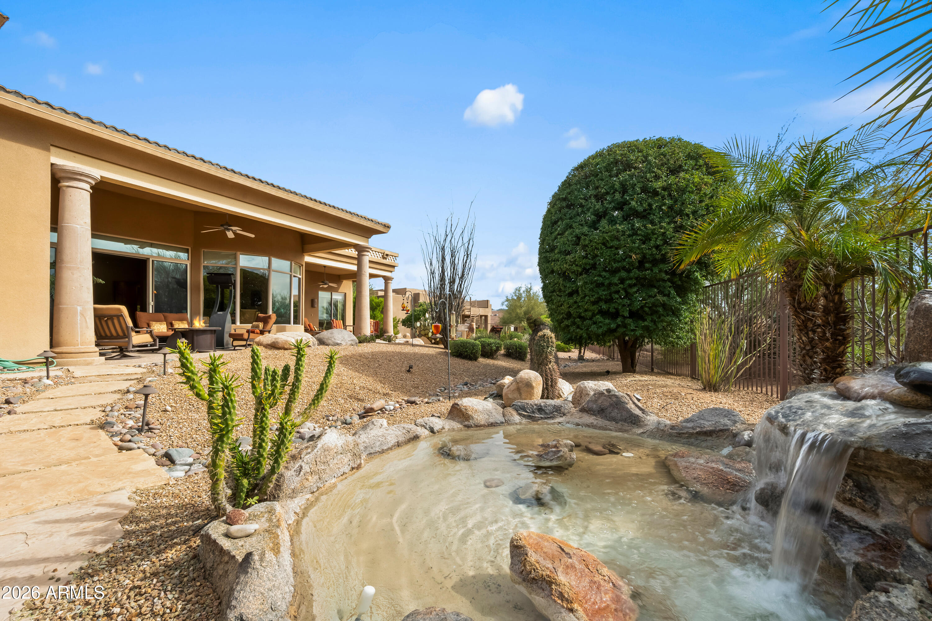 18513 East Agua Verde Drive Rio Verde, AZ 85263 - Photo 40 of 42 a view of a swimming pool with a lawn chairs under an umbrella