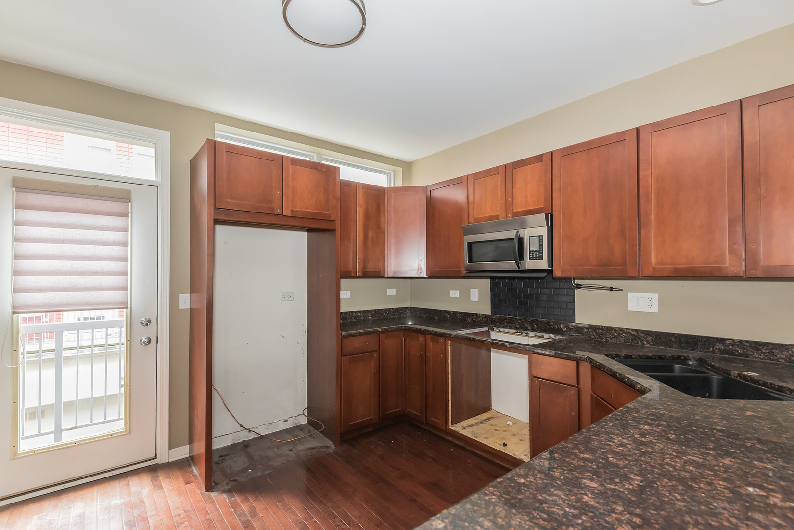 16 South Aberdeen Street, Unit 9 Chicago, IL 60607 - Photo 12 of 24 a kitchen with stainless steel appliances granite countertop a stove a sink dishwasher a refrigerator and cabinets with wooden floor