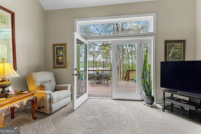 a living room with furniture a flat screen tv and floor to ceiling window
