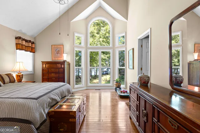 a spacious bedroom with a balcony a bed and a dresser next to a window