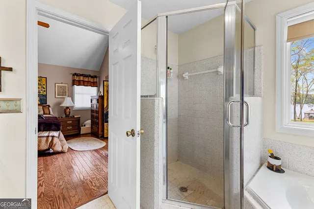a en suite bathroom with a shower sink and mirror