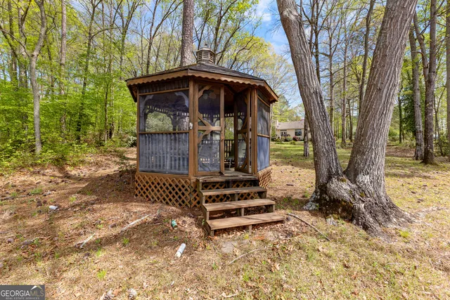 a view of a yard with wooden fence and a large tree