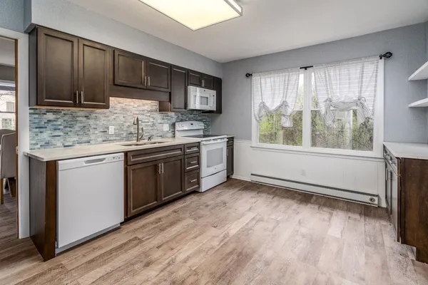 a kitchen with stainless steel appliances granite countertop a stove a sink and a microwave