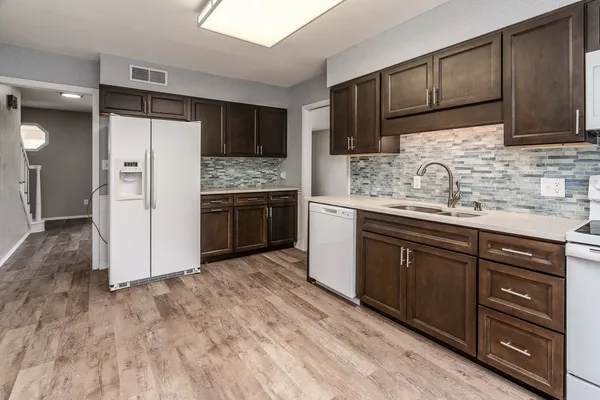 a kitchen with stainless steel appliances granite countertop a refrigerator and a stove top oven