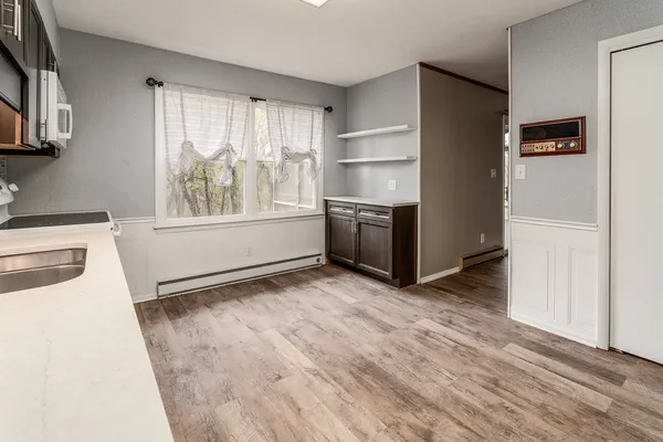 a view of kitchen with wooden floor electronic appliances and windows