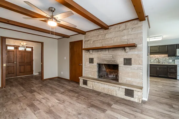 a view of a livingroom with a fireplace wooden floor and staircase