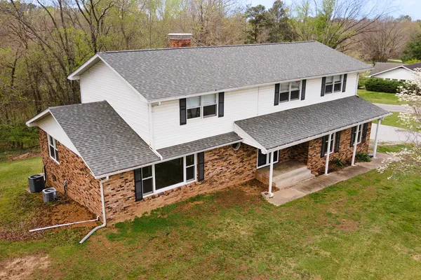 a aerial view of a house with swimming pool next to a yard