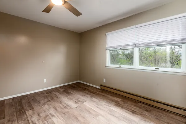 an empty room with closet and a ceiling fan