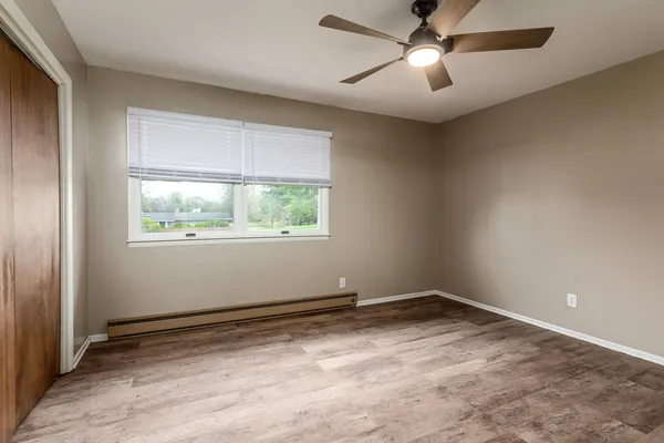 an empty room with closet and a ceiling fan
