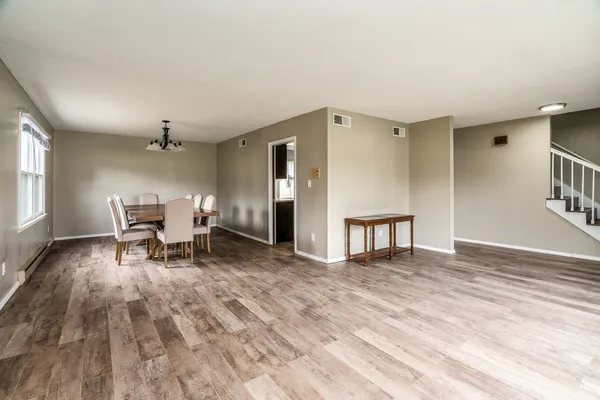 a living room with furniture and a dining table with kitchen view