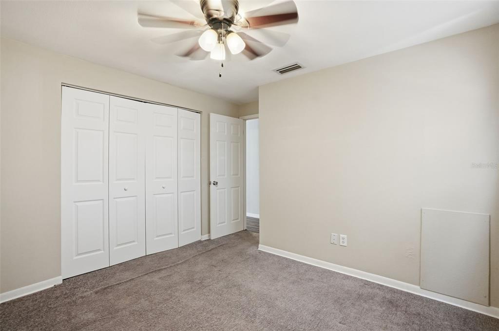 9543 Century Drive Spring Hill, FL 34608 - Photo 15 of 25 an empty room with a chandelier fan and windows