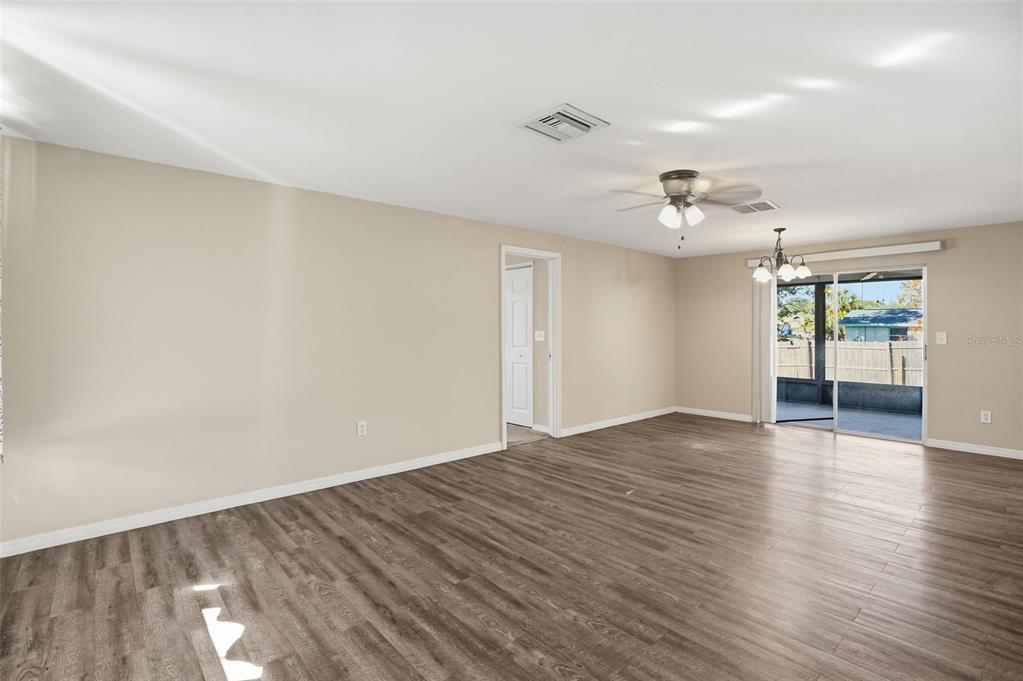 9543 Century Drive Spring Hill, FL 34608 - Photo 7 of 25 a view of an empty room with wooden floor and a window