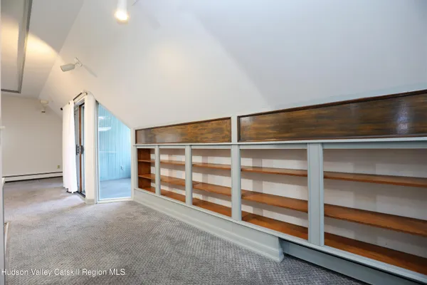 a view of an empty room with a fireplace and a cabinet