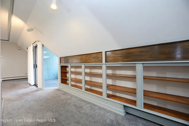a view of an empty room with a fireplace and a cabinet