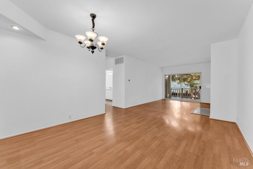 135 Koch Road Corte Madera, CA 94925 - Photo 7 of 57 a view of an empty room with chandelier fan and wooden floor
