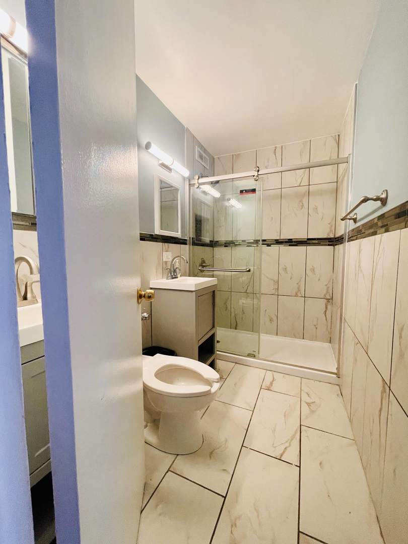 1451 East 55th Street, Unit 1030N Chicago, IL 60615 - Photo 7 of 18 a bathroom with a sink toilet and shower