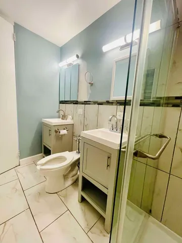 a bathroom with a toilet sink and mirror