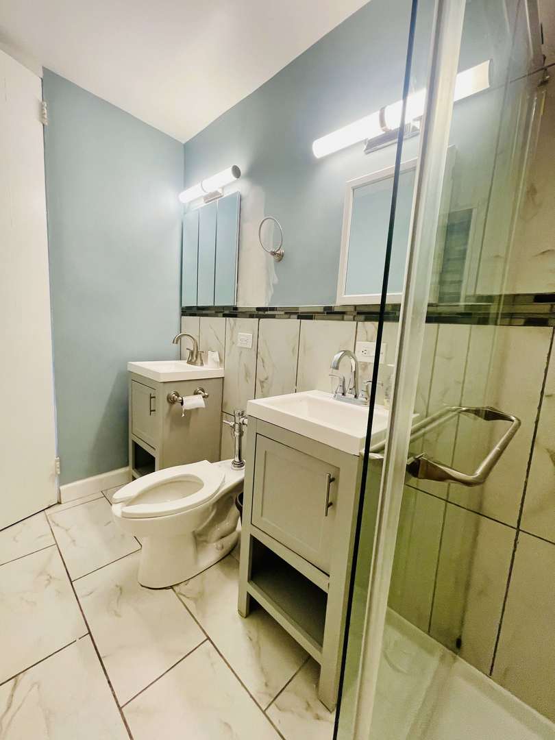 1451 East 55th Street, Unit 1030N Chicago, IL 60615 - Photo 8 of 18 a bathroom with a toilet sink and mirror